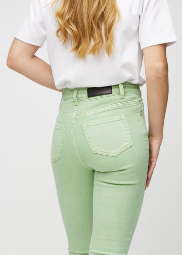Skinny jeans for women in light green, color Mints. Close-up back view on a model, showing details.