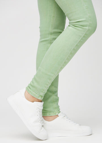Skinny jeans for women in light green, color Mints. Close-up of the snug-fitting leg openings at the ankles on a model.