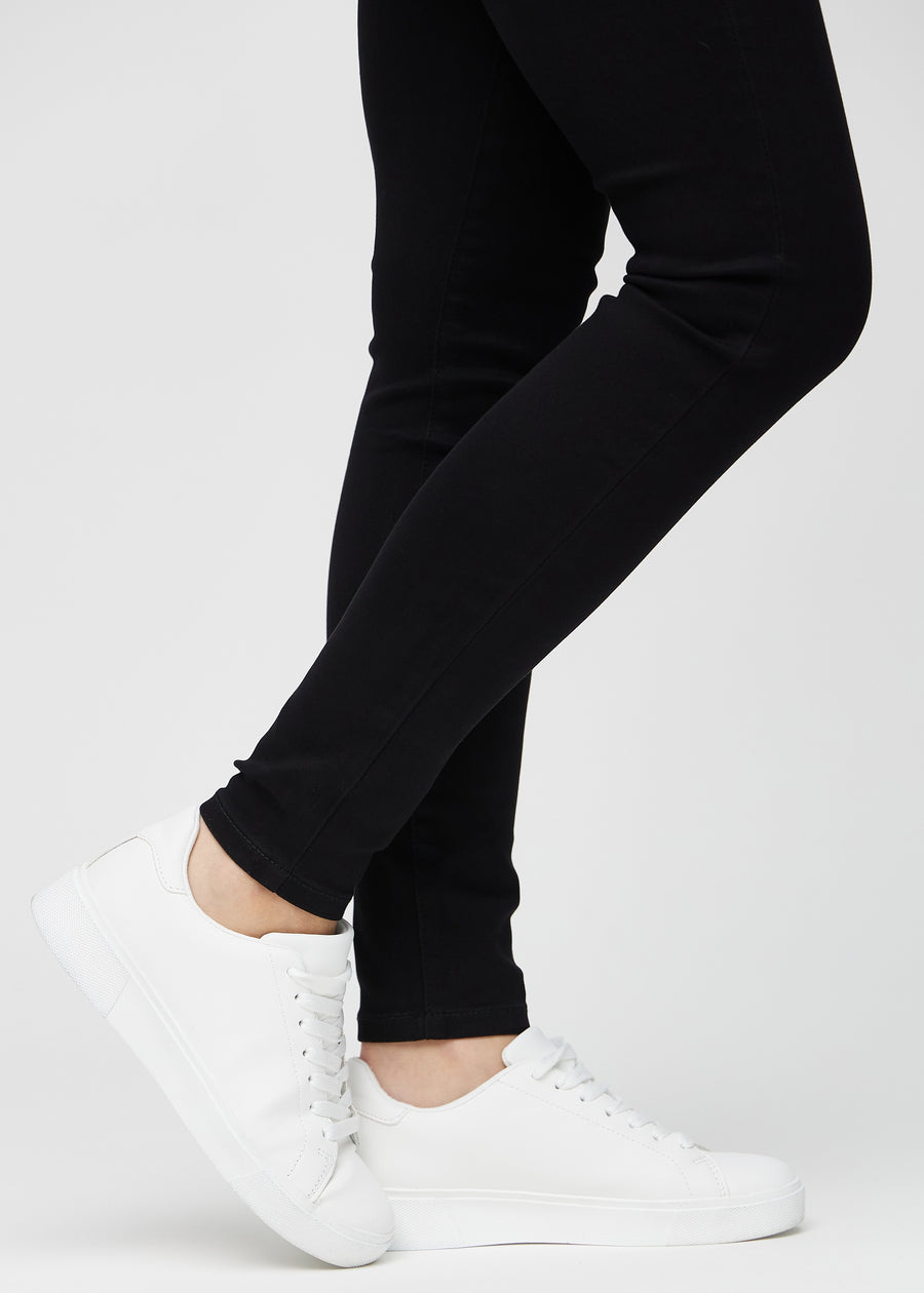 The ankles of a model, so you can see how tightly the jeans fit in a Skinny fit.