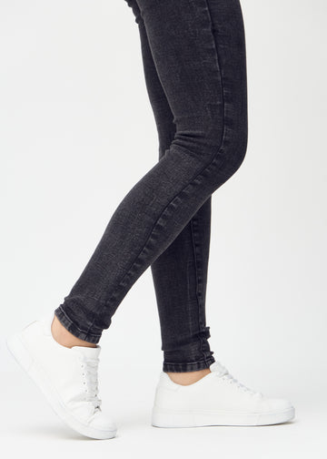 Skinny jeans for women in dark grey, color Shadows. Close-up of the snug-fitting leg openings at the ankles on a model.