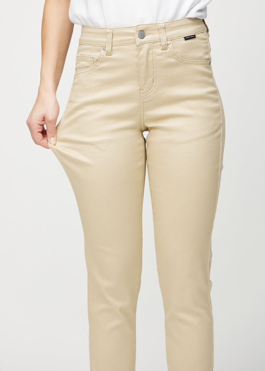 Slim jeans for women in beige, color Gazelles. A model stretches the jeans at the thigh to show the fabric&