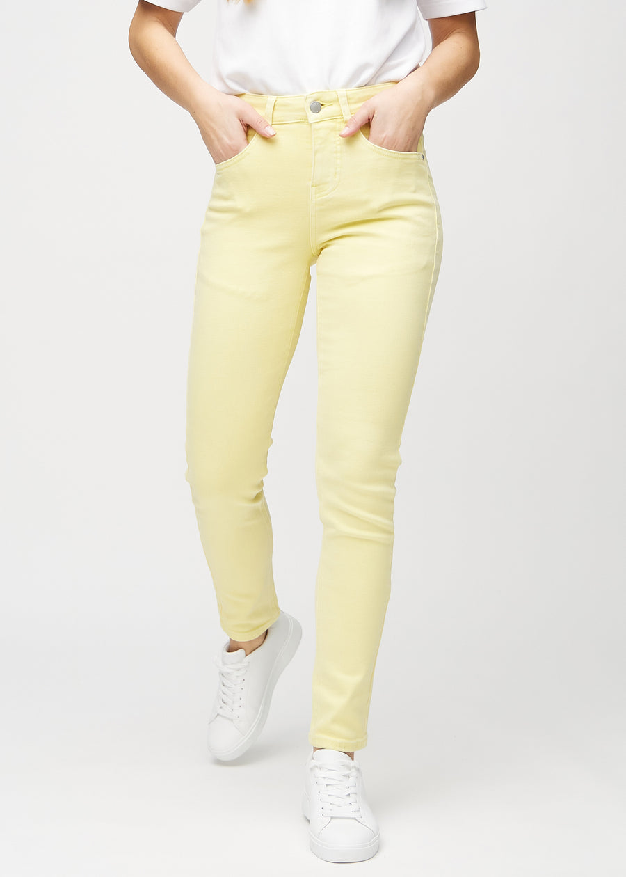 Slim jeans for women in light yellow, color Lemonades. Front view on a model, showing a close fit through the leg with a little more room at the ankle.