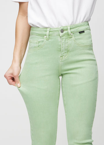 Slim jeans for women in light green, color Mints. A model stretches the jeans at the thigh to show the fabric&