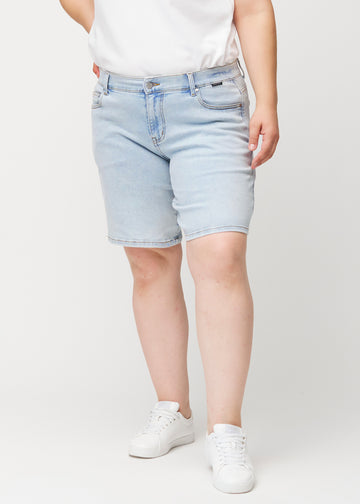 Front view of a female model wearing light blue Waves denim shorts with a mid-rise waist and loose fit.