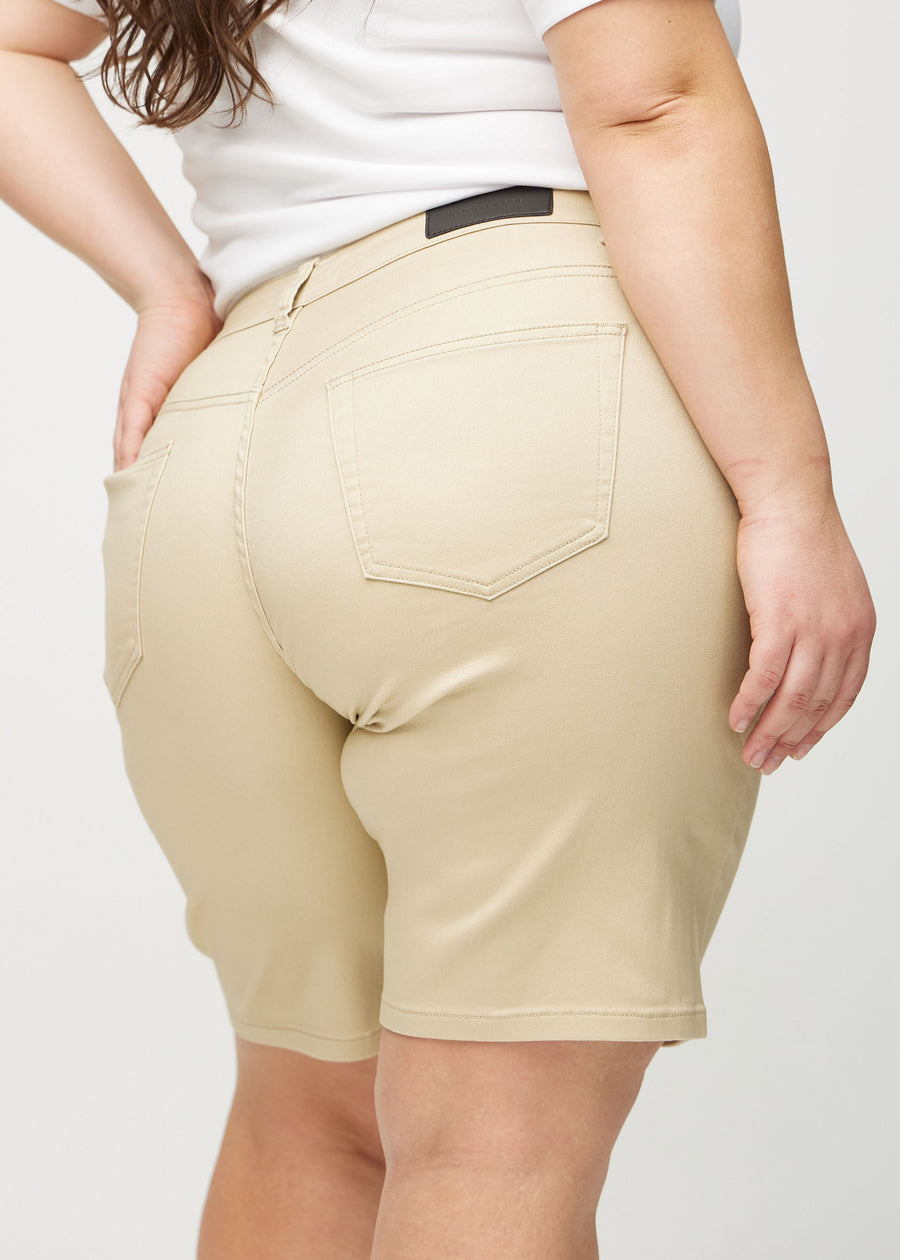 Beige regular middle shorts seen from the back close up on a plus-size model to show details.
