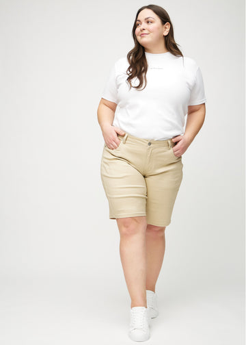 Full image of a plus-size model wearing beige regular middle shorts.