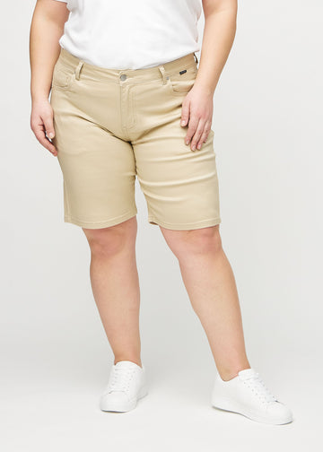 Beige regular middle shorts, model name Gazelles, which go straight down the leg and end just above the knee on a plus-size model, seen from the front.