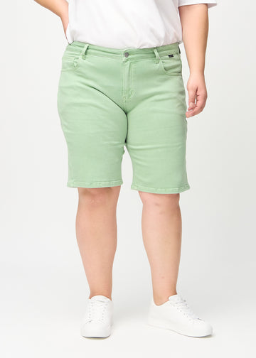 Light green regular middle shorts, model name Mints, which fall straight down the leg and end just above the knee on a plus-size model, seen from the front.