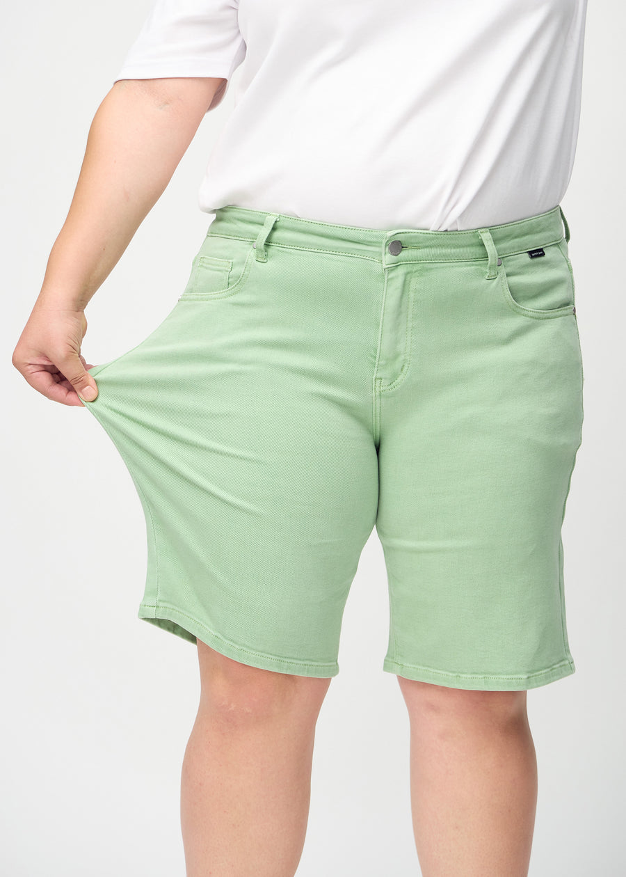 The plus-size model stretches the shorts at the thigh to show the stretch.