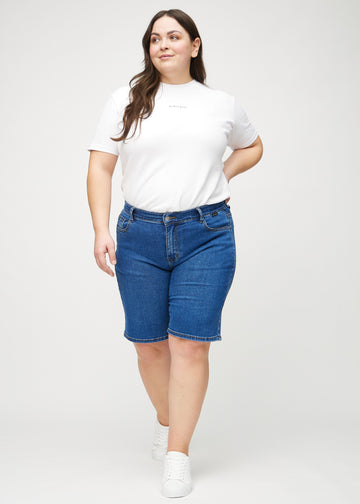 Full image of a plus-size model in dark denim regular middle shorts.