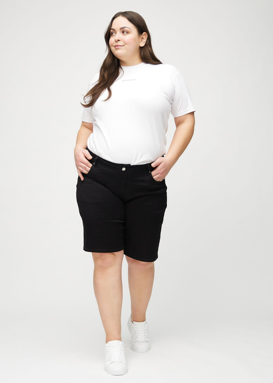 Full image of a plus-size model wearing black regular middle shorts.