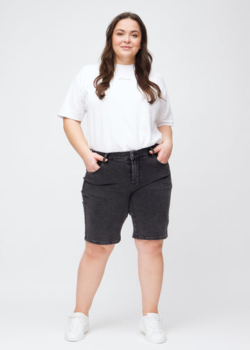Full image of a plus-size model in dark grey denim regular middle shorts.