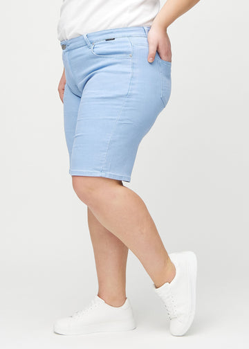 Light blue regular middle shorts seen from the side on a plus-size model.