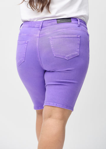 Purple skinny middle shorts seen from the back close up on a plus-size model to show details.
