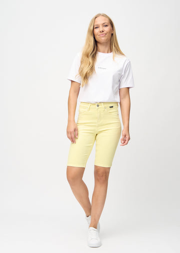 Full image of a model in light yellow skinny middle shorts.