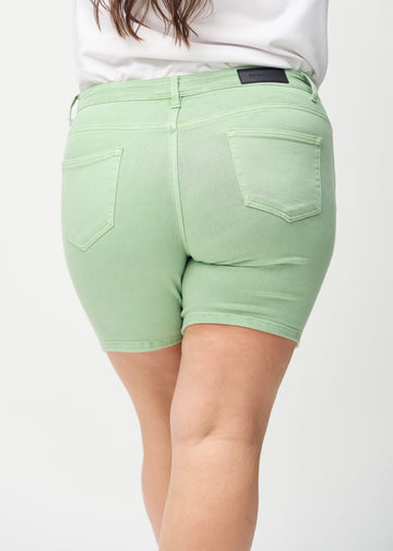 Light green skinny short shorts seen from the back close up on a plus-size model to show details.