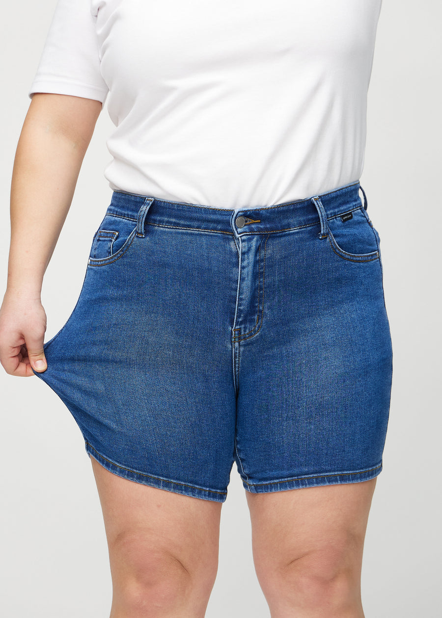 Plus-size model stretches the shorts at the thigh to show the stretch.