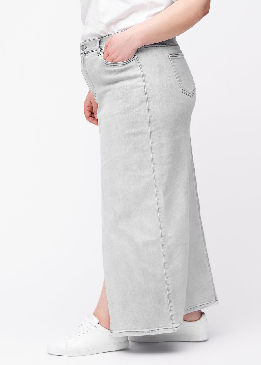 Long light grey denim skirt for women in the color Ashes. Side view on a plus-size model, with the front slit visible.