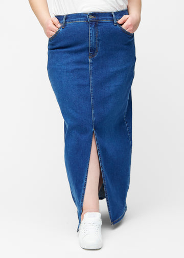 Lang, mørkeblå denimnederdel i farven Oceans med regulær pasform set forfra på plus-size model, med slids foran der starter lige under knæet.