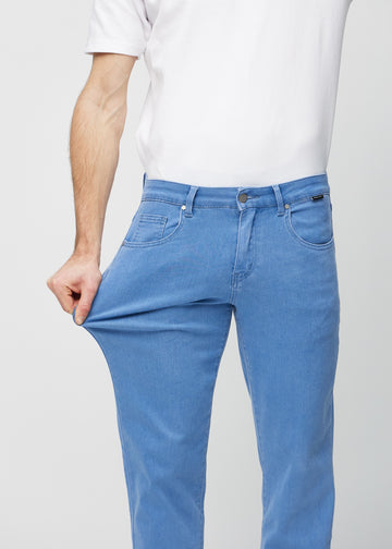 The model stretches the jeans at the thigh to show the stretch.