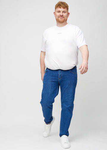 Full image of a plus-size model in dark blue denim regular jeans.