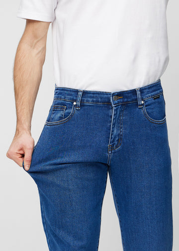 The model stretches the jeans at the thigh to show the stretch.
