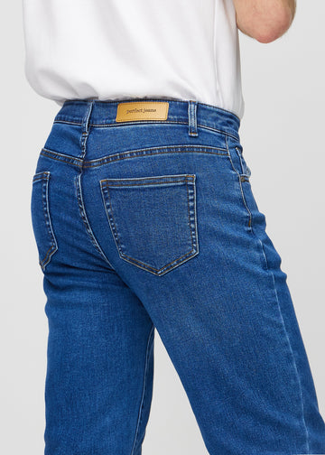 Dark blue denim regular jeans seen from the back close up to show details.