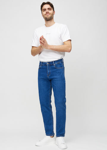 Full image of model in dark blue denim regular jeans.