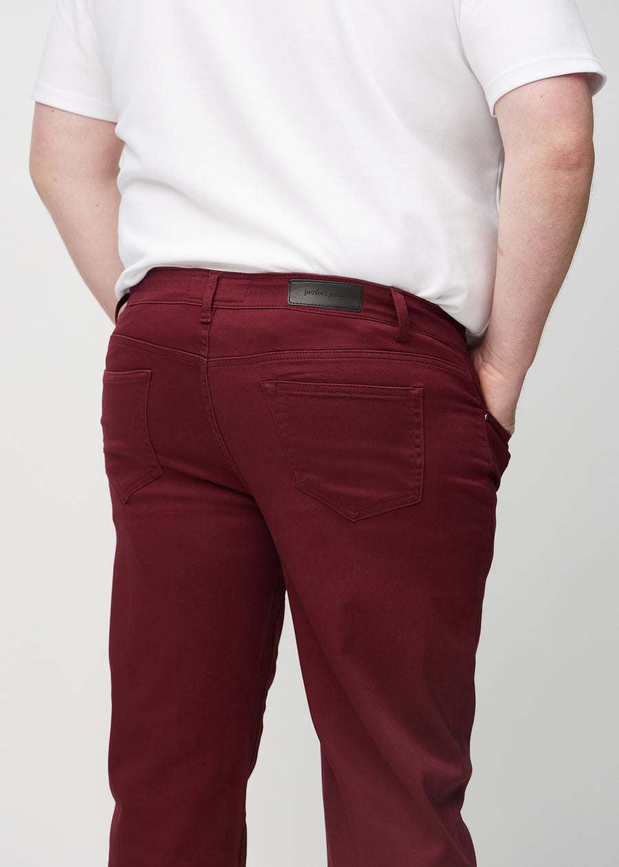 Dark red regular jeans seen from the back close up on a plus-size model to show details.
