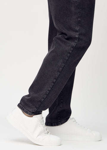 The ankles of a plus-size model, so you can see how loose the jeans fit.