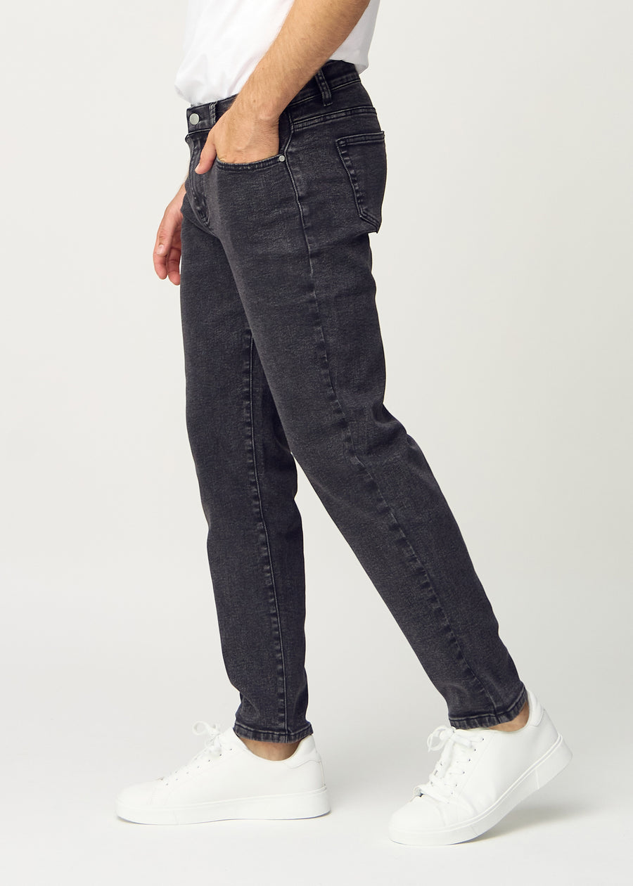 Dark grey denim regular jeans viewed from the side on a model.