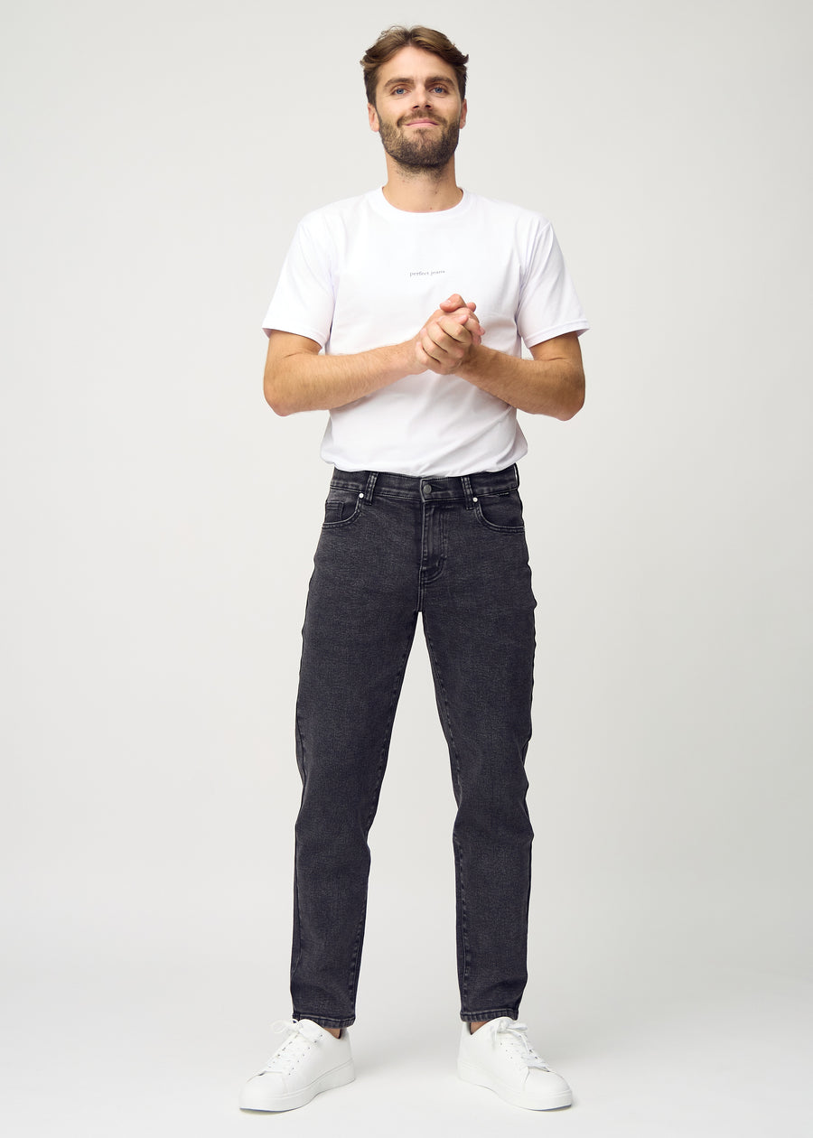 Full image of model in dark grey denim regular jeans.