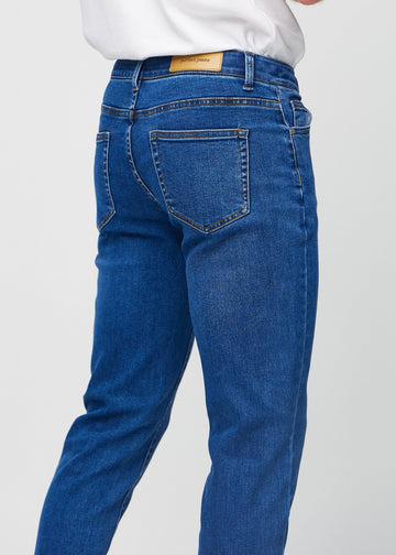 Close-up back view of dark blue denim slim jeans showing details.