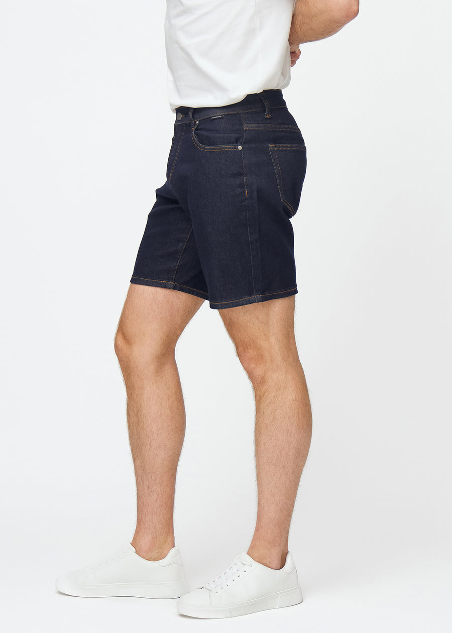 deep dark blue denim shorts for men in the colour midnights with a regular fit seen from the side on a model.