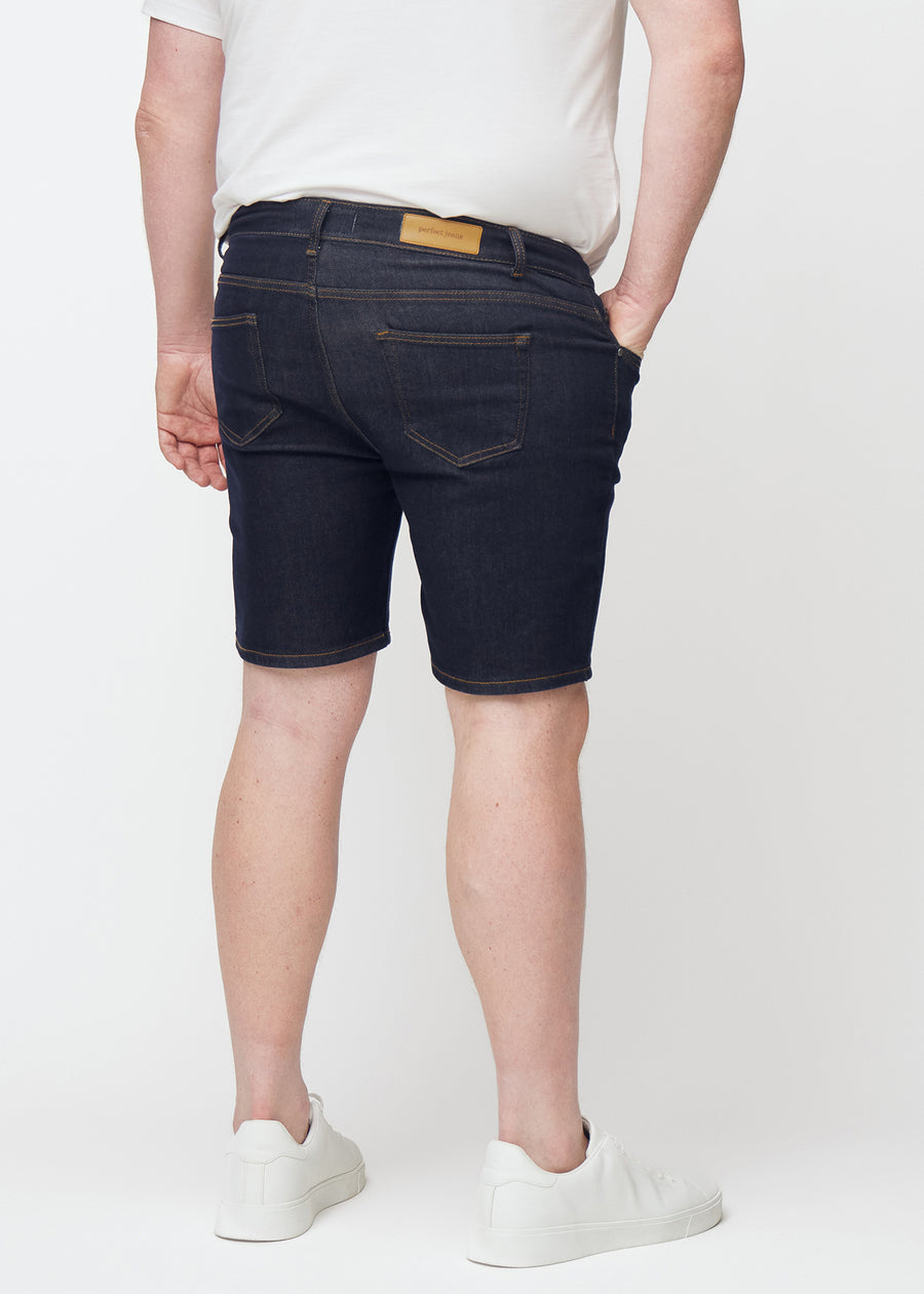 Deep dark blue denim shorts for men in the colour Midnights seen from the back on a plus-size model.