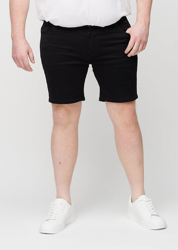 Black middle-slim shorts, which fit straight along the thigh and end just above the knee on a plus-size model, seen from the front.