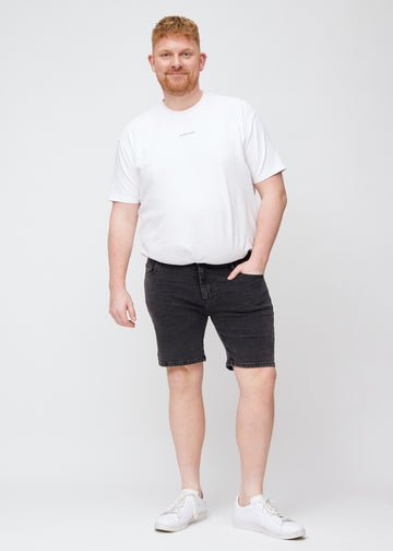 Full image of a plus-size model in dark grey denim middle-slim shorts.