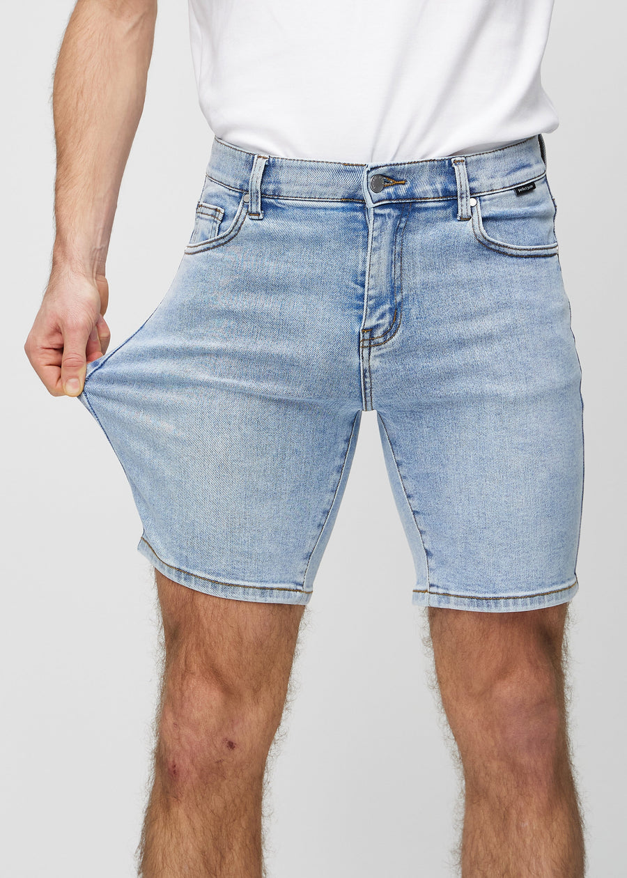 The model stretches the shorts at the thigh to show the stretch.